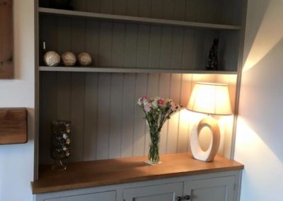 Handmade cabinets with log store and bookshelves spray finished in Hardwick White