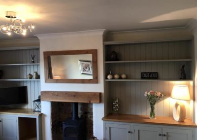 Handmade cabinets with log store and bookshelves spray finished in Hardwick White